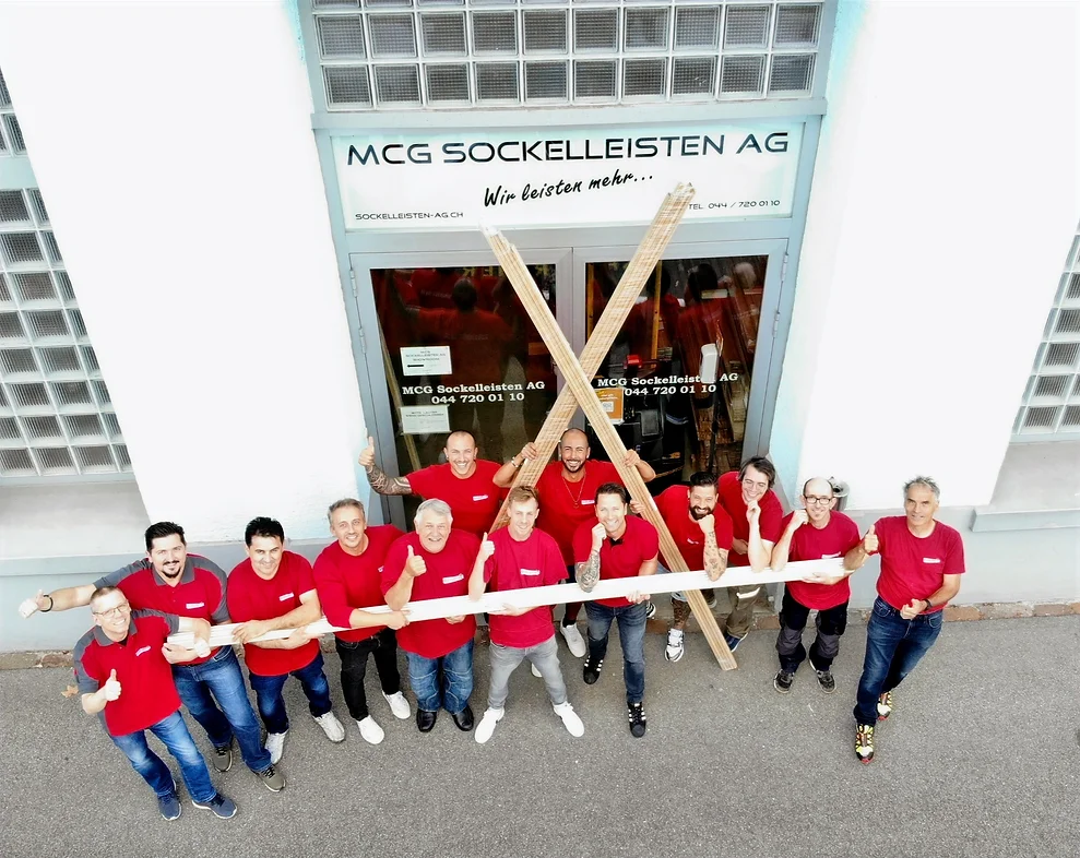 Das Team der MCG Sockelleisten AG versammelt vor dem Firmengebäude.